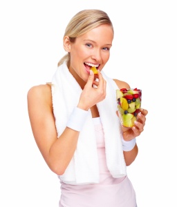 Young happy woman eating fruits isolated over white background